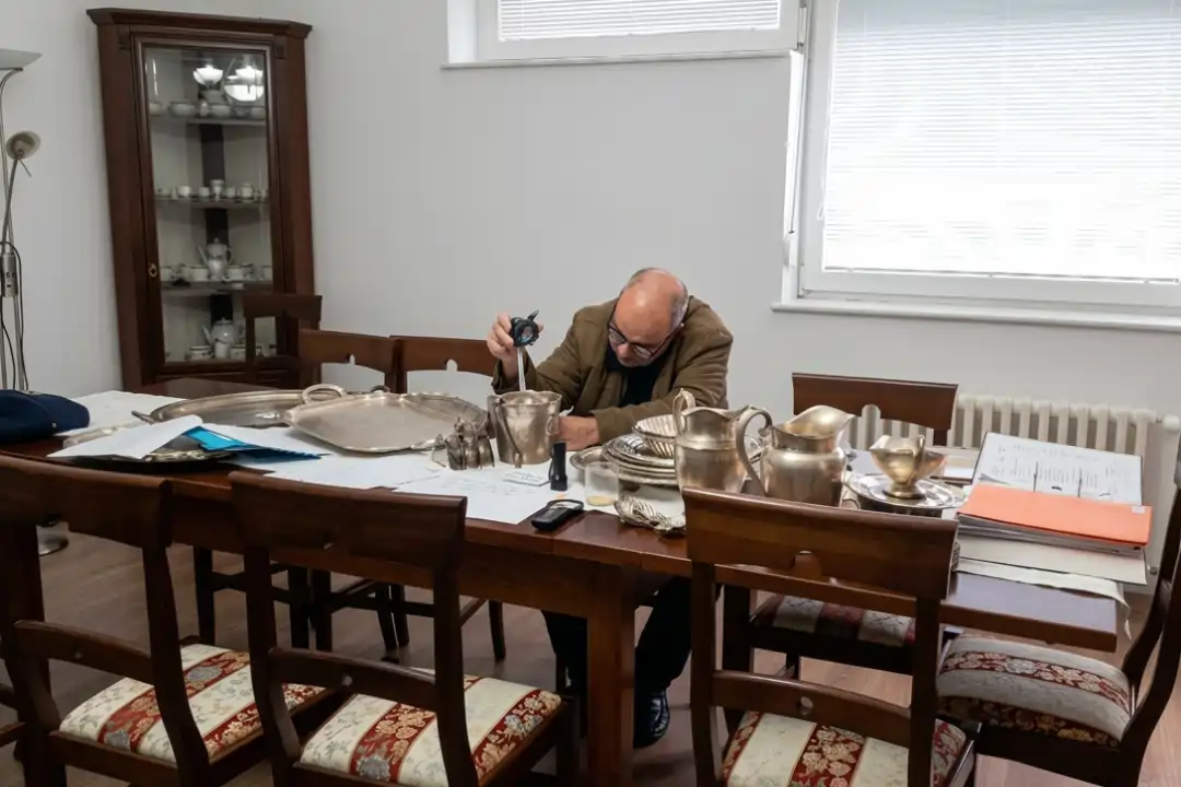 Luis Manuel Almeida revisando bienes en mesa de trabajo, proceso de peritaje hereditario